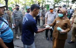 Bupati Jombang, Hj. Mundjidah Wahab saat menyerahkan masker gratis kepada warga Jombang. (Foto: doc)